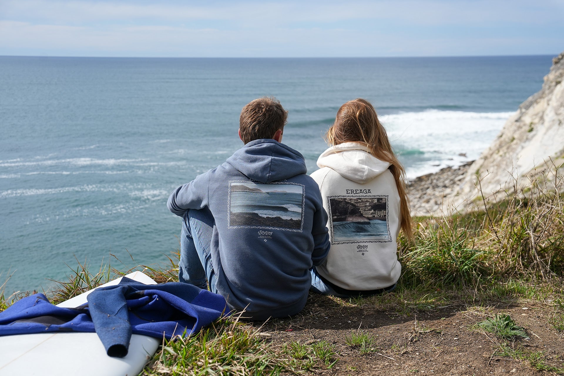 Una pareja de jovenes mirando al mar en un acantilado