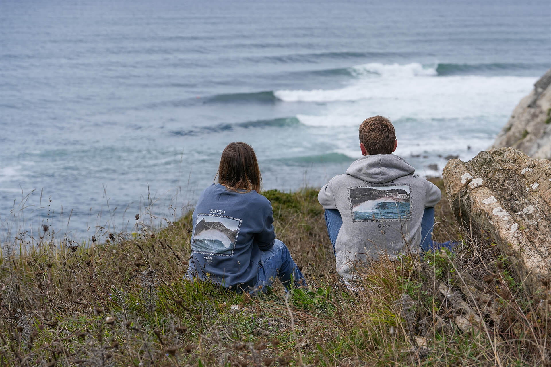 Una pareja de jovenes mirando al mar en un acantilado